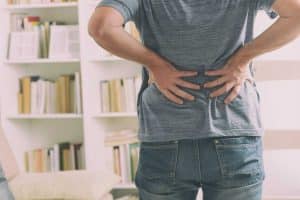 A man in gray shirt will lower back pain