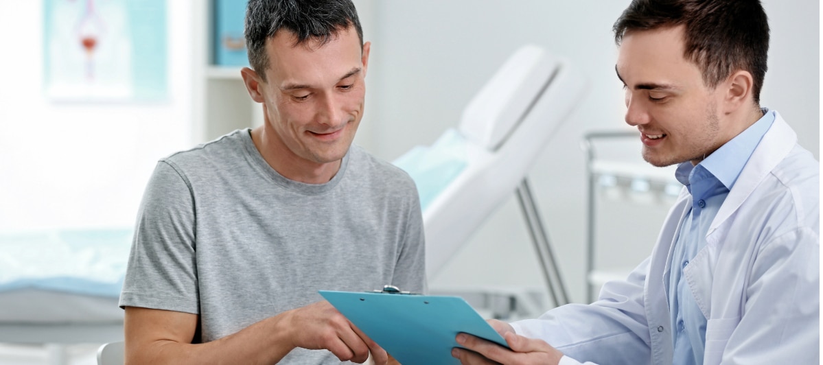 Reduce Chronic Pain with a Peripheral Nerve Stimulator for CRPS-4-Doc and Patient A doctor in a lab coat shows a patient a clipboard with information about CRPS