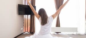 A woman sitting in bed stretches due to improved mobility from sacroiliac joint injections