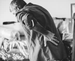 A man with back pain holding his lower back