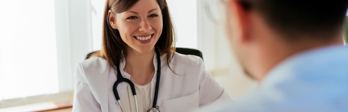 Stage 2 Hypertension When Blood Pressure Gets Serious-3 A doctor in a lab coat smiles as she talks with a patient about managing hypertension
