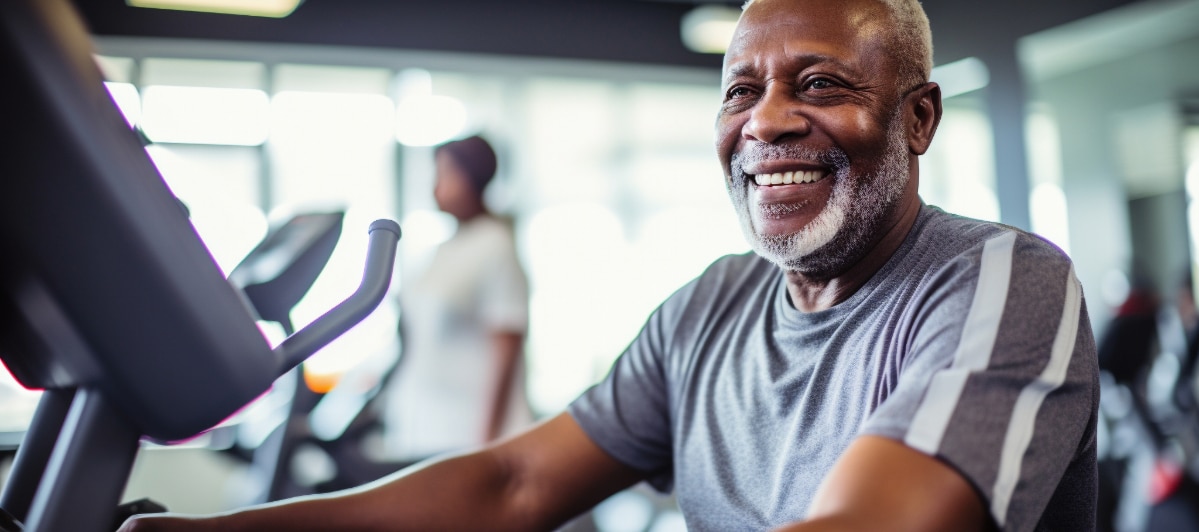 A man smiles as he exercises on an elliptical machine