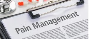 A clipboard with the words "pain management" on the paper