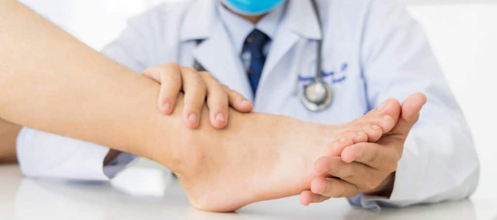 A doctor examines a patient's foot to diagnose diabetic neuropathy