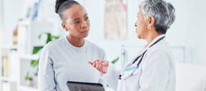 A patient listens as her doctor talks about the pros and cons of kyphoplasty