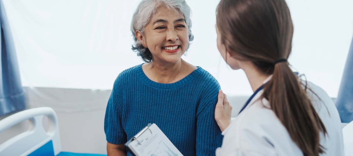 The Pros and Cons of Kyphoplasty-5-Happy A patient smiles as her doctor discusses the pros and cons of kyphoplasty