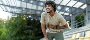 A runner stops and holds his stomach as he feels the effects of inflammation and weight gain