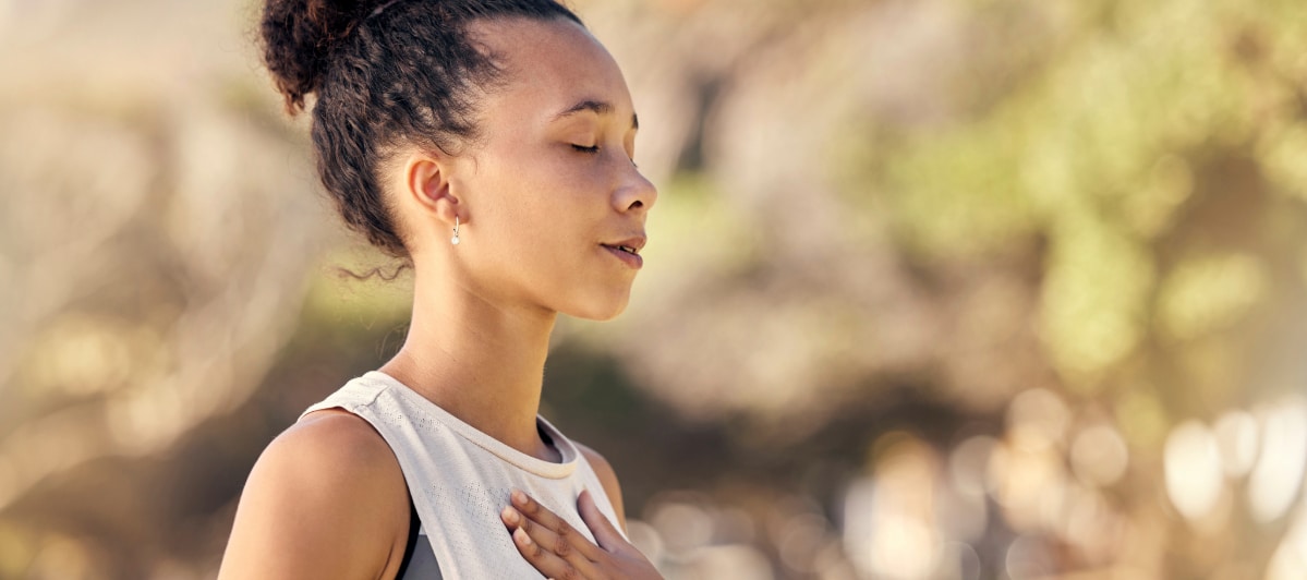The Science Behind Platelet-Rich Plasma Therapy-3-Peaceful A woman closes her eyes, smiles and puts her hand to her chest after platelet-rich plasma therapy