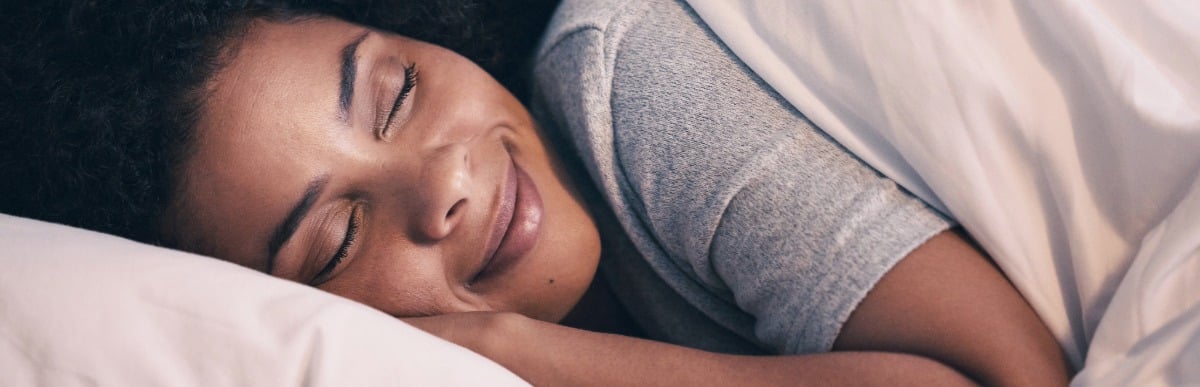 Top 5 Benefits of Using a CGM Sensor Daily-2 A woman smiles as she enjoys better sleep with diabetes management using a CGM sensor