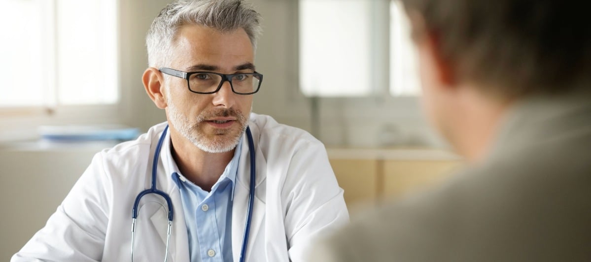 Types of Spine Surgery Explained-6-Doc A doctor in a lab coat discuss the types of spine surgery with a patient