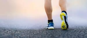 A person with athletic shoes on walks as treatment for the stages of diabetic neuropathy