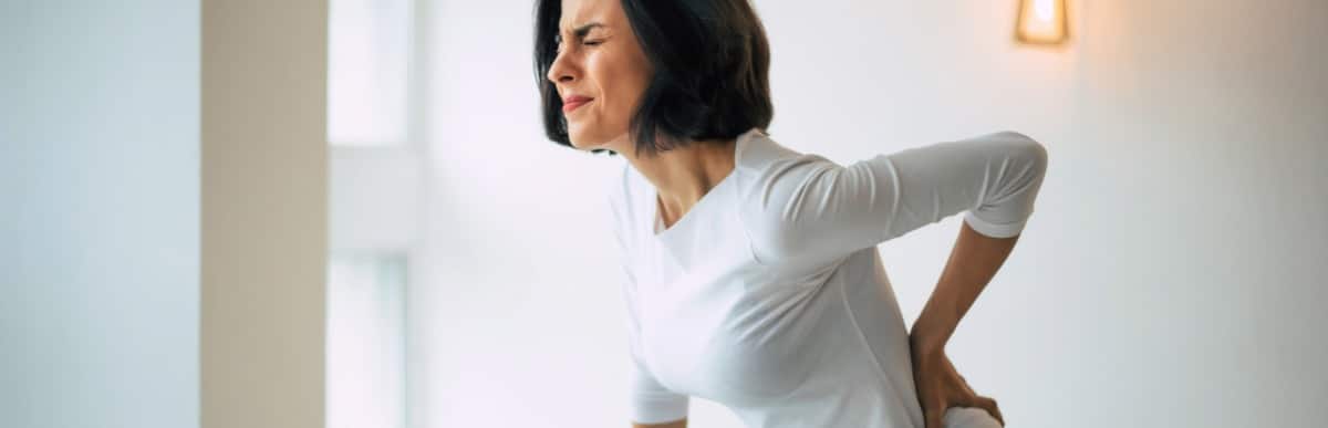 What Is an Epidural Injection-4-Pain A woman considering epidural injection treatment holds her back in pain