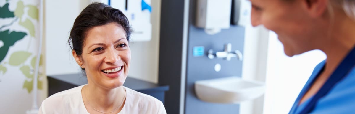 What Is an Epidural Injection-5-Doc A patient smiles while meeting with her doctor after an epidural injection session