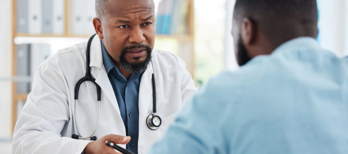 What Is the Best Treatment for Spinal Stenosis-2-Doctor A doctor in a lab coat speaks with his patient about treatment for spinal stenosis