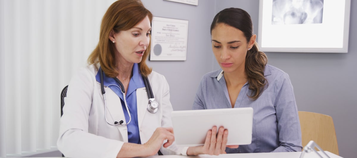 What Alternative Medicine Can Do For You-3-Doc A doctor in a lab coat explain options for regenerative medicine to a patient