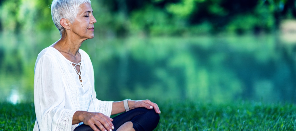 What Alternative Medicine Can Do For You-6-Yoga (1) A woman sits cross-legged next to a lake after regenerative medicine treatment