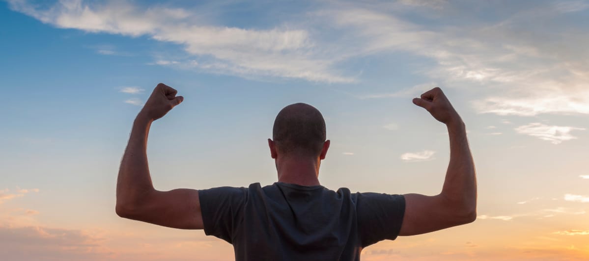 What Alternative Medicine Can Do For You-7-Strong A man flexes his biceps after testosterone replacement therapy as part of regenerative medicine treatment