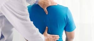 A doctor examines a patient's back before spinal decompression treatment