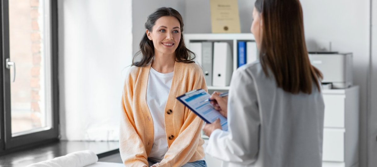 What You Need to Know About Surgical Decompression-4-Patient A patient smiles as her doctor talks during a follow-up appointment after surgical decompression