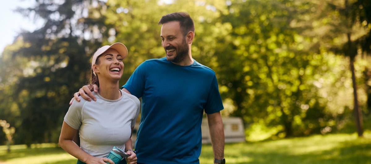 What to Expect During a Neural Therapy Session-7-Laugh A couple laughs as they walk through the park after a neural therapy session