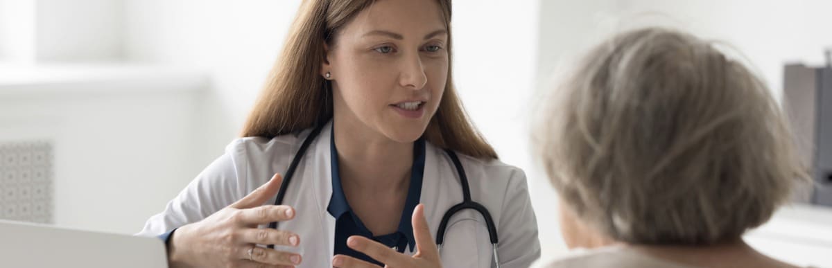 What to Expect When Getting a Glucose Monitoring Implant (19) A doctor in a lab coat discuss lower back pain after surgery with a patient