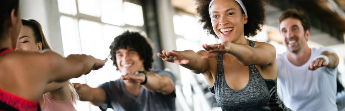 What to Expect When Getting a Glucose Monitoring Implant (21) A woman holds a pose in yoga class and smiles as she feels less lower back pain after surgery