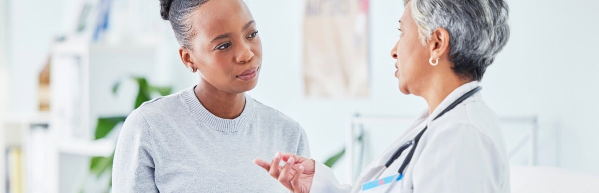 What to Expect When Getting a Glucose Monitoring Implant-4 A doctor talks to her patient after a glucose monitoring implant procedure about proper aftercare