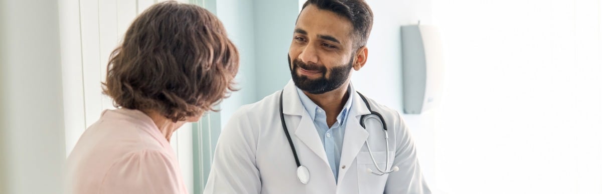 When to Eat to Optimize Health and Wellness-4-Doc A doctor smiles as he talks with a patient about alternative pain relief