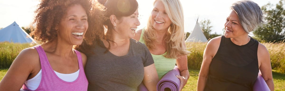 When to Eat to Optimize Health and Wellness-6-Yoga A group of friends smile and laugh after yoga class as part of their alternative pain relief