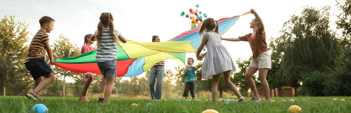 Why Blood Sugar Support Matters at Every Age-3 A group of children play with a parachute at a playground