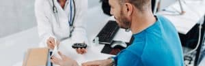 A doctor checks a patient's glucose levels as part of a blood sugar support program