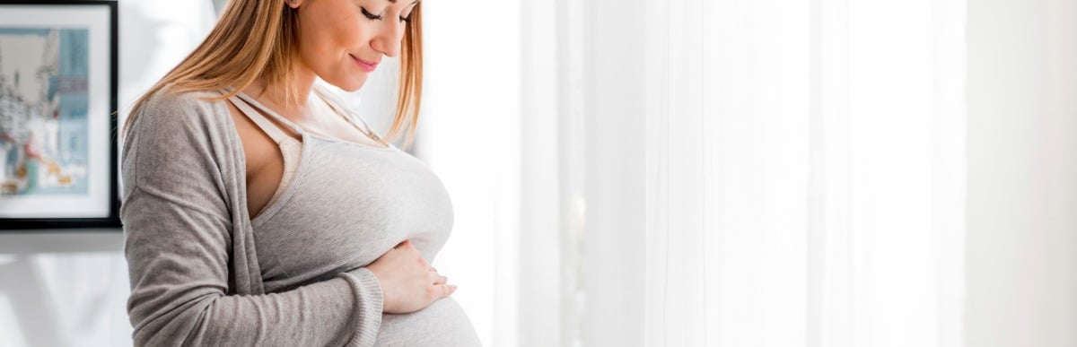 Why Blood Sugar Support Matters at Every Age-4 A pregnant woman smiles and holds her stomach