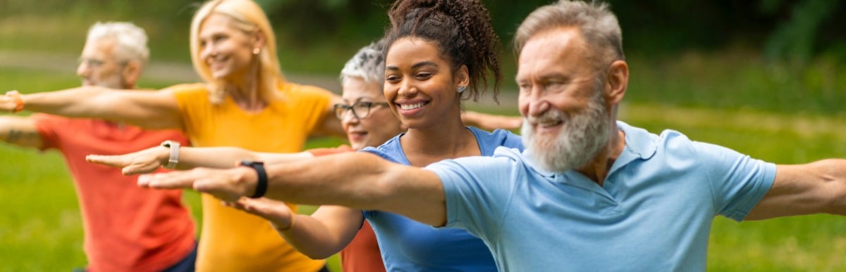 Why Blood Sugar Support Matters at Every Age-5 People in a yoga class smile as they hold a pose as part of blood sugar support for diabetics