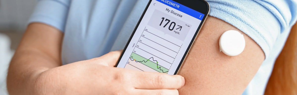 Why CGMs Are Changing Diabetes Care-3 A man checks a modern version of CGMs with his phone