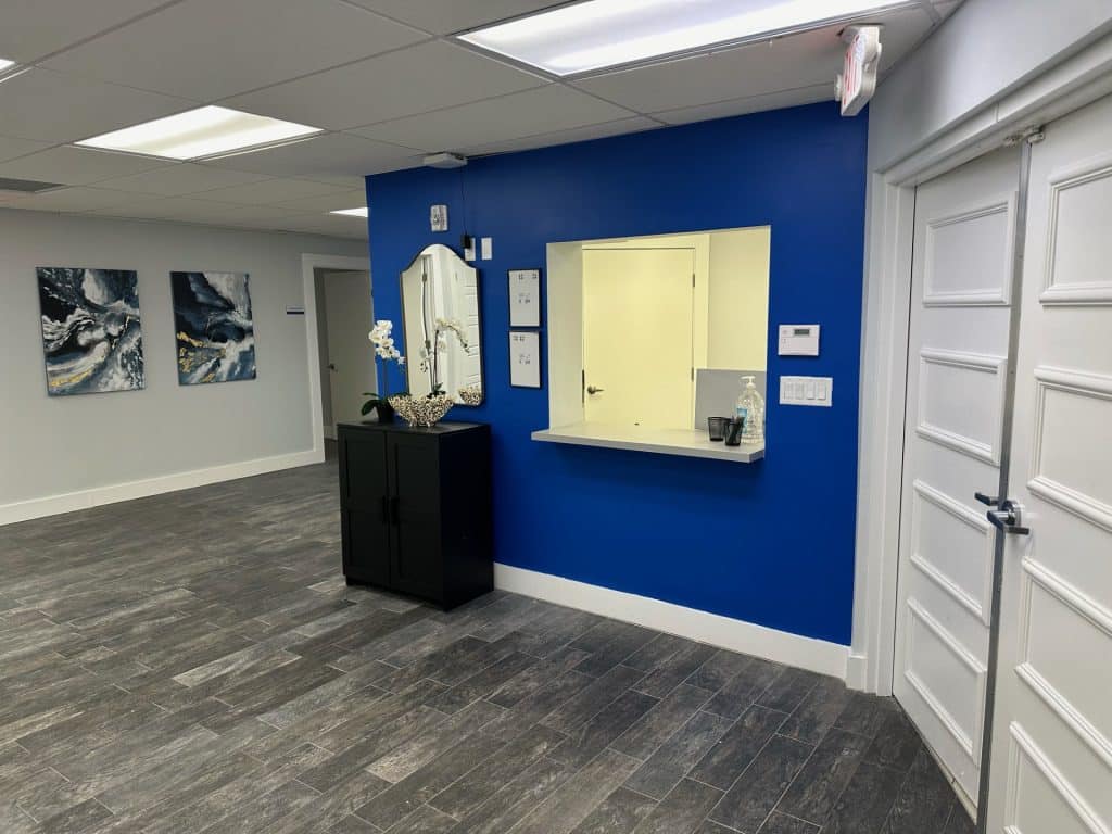 Inside a waiting with blue walls and wood floors at pain and spine specialists of florida.