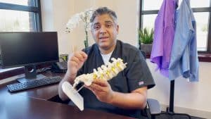 Dr.Sudhir Rao holding spinal model explaining
